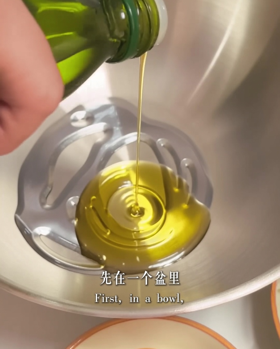 Olive oil and two pieces of butter sitting in a metal mixing bowl, ready to be prepared for the sauce base.