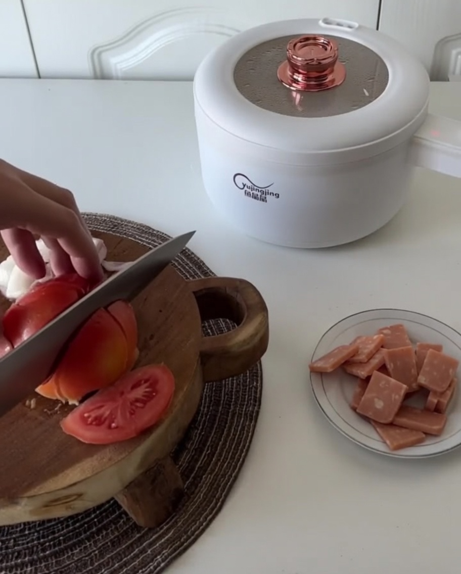 The steamed tomato being chopped into smaller pieces on the wooden board.