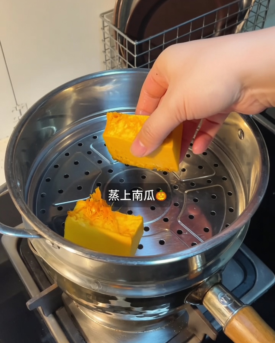 Steamed pumpkin pieces in a metal steamer basket.