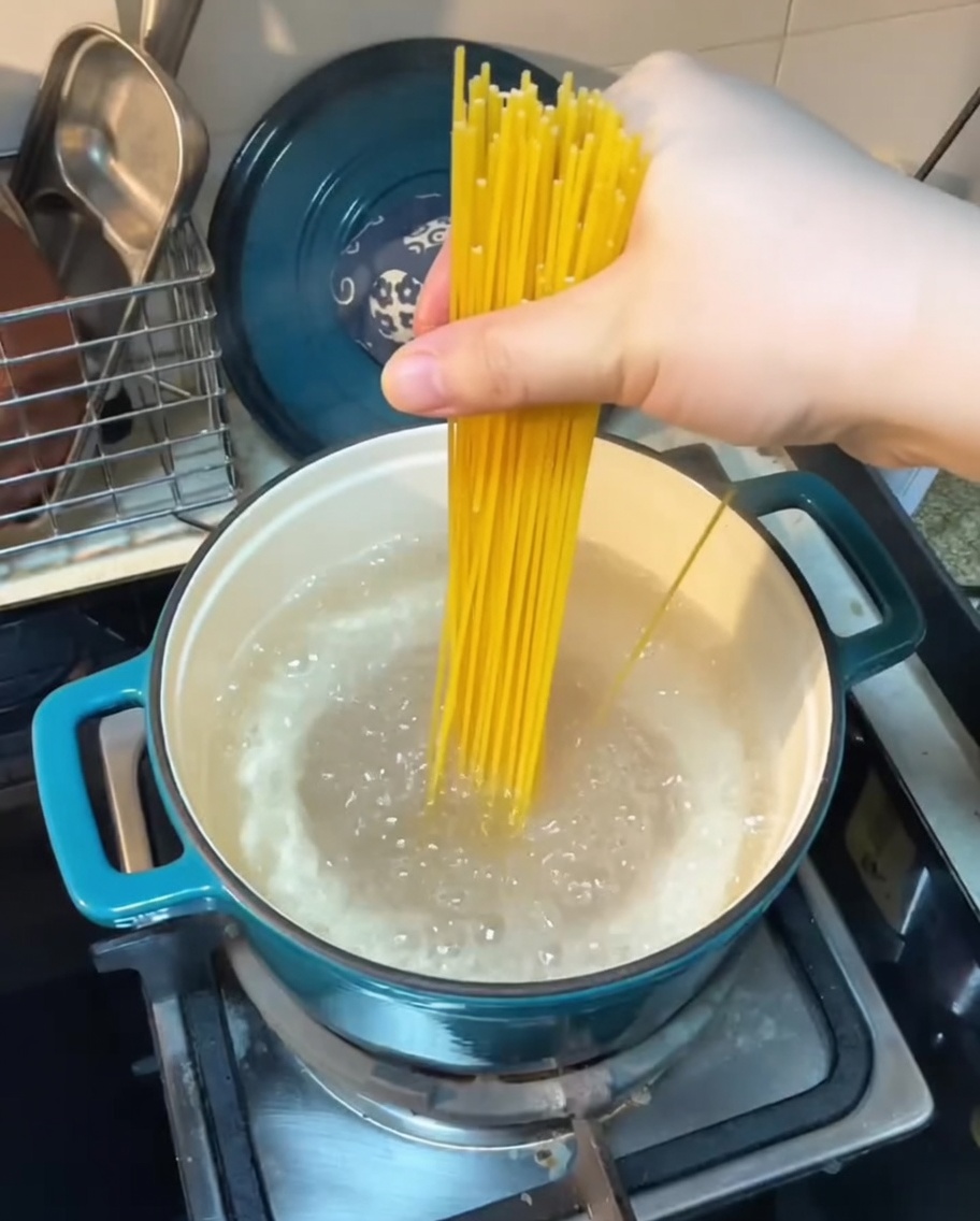 Spaghetti cooking in a pot of boiling water.