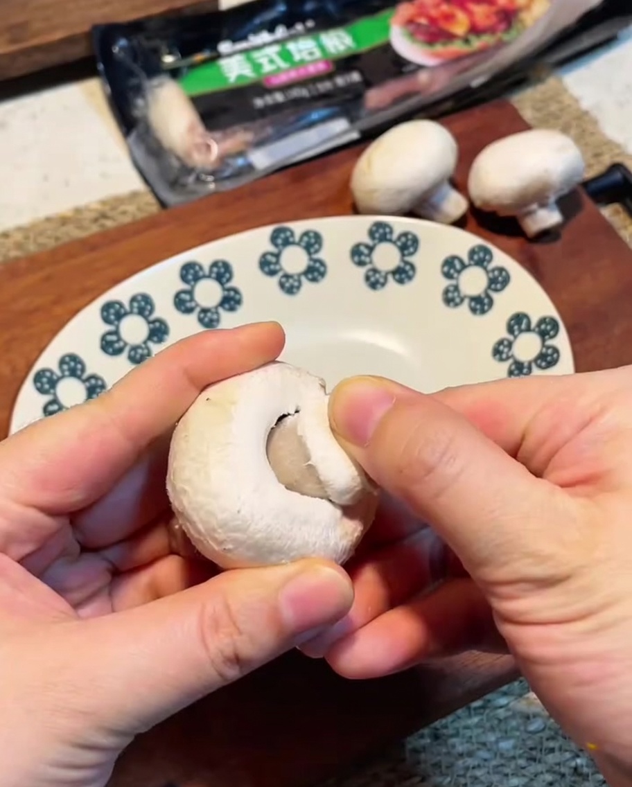 Sliced mushrooms arranged on a wooden cutting board.