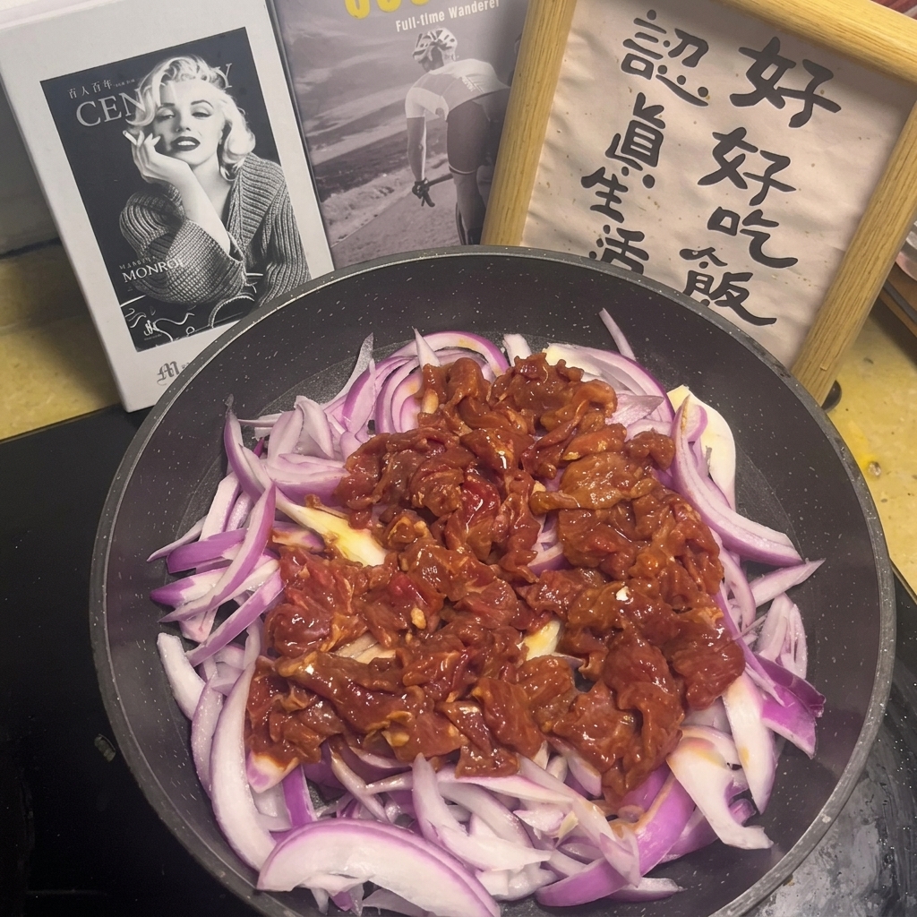 A sauce mixture with visible garlic and chili pieces being poured over the raw beef and onions in the pan.