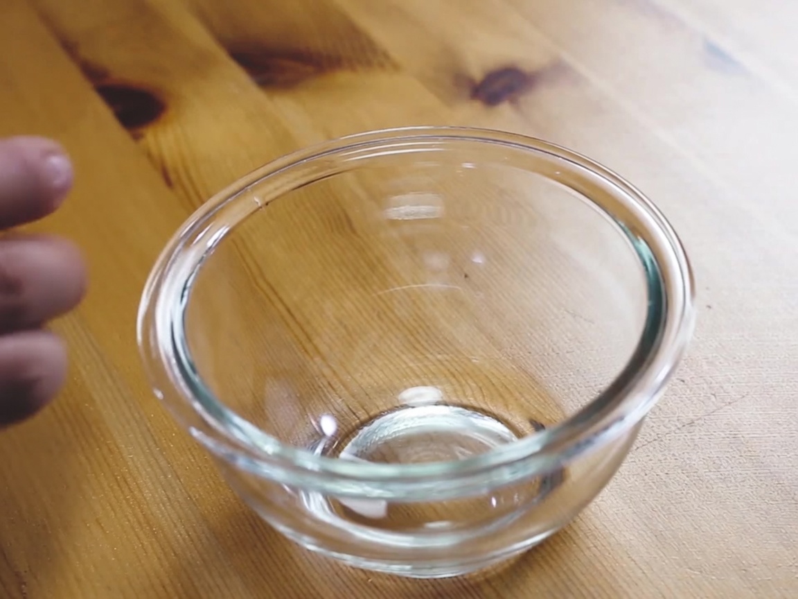 A whisked mixture of egg, milk, and mayonnaise in a clear glass bowl.