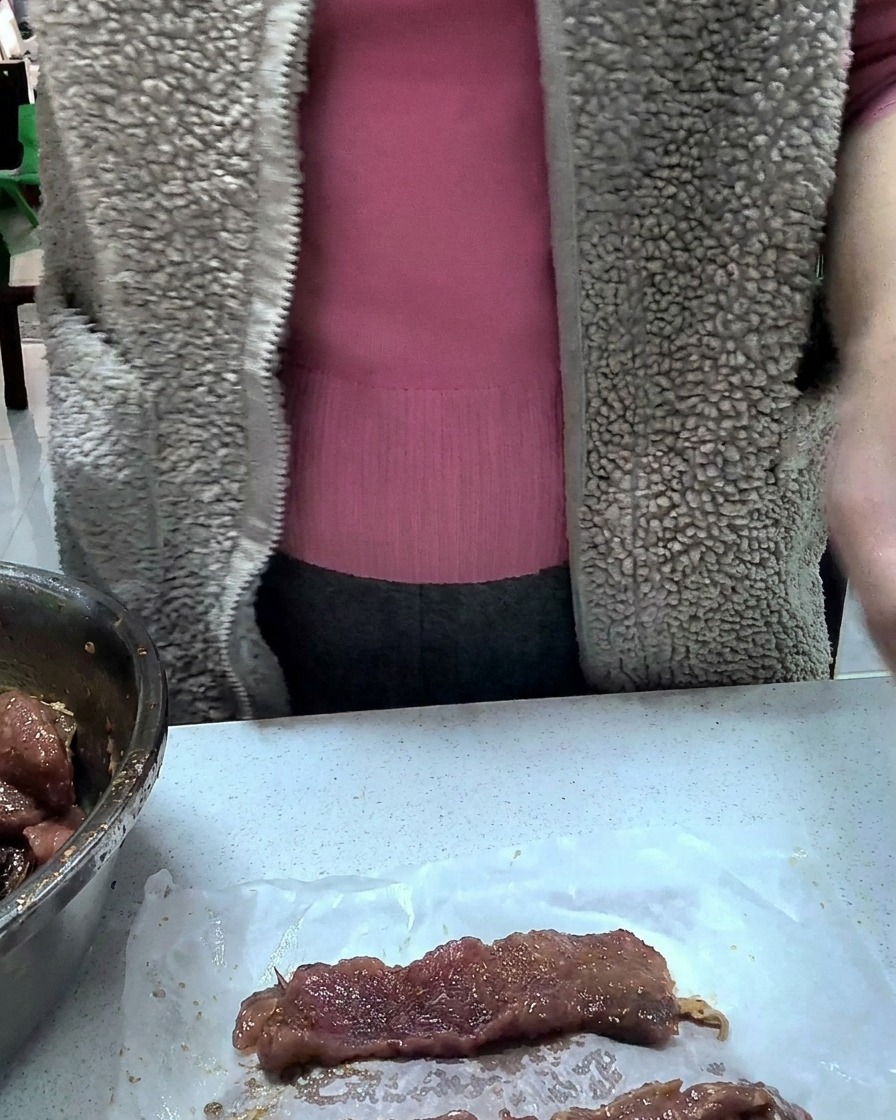 Individual portions of marinated pork neatly wrapped in plastic film on a kitchen counter.