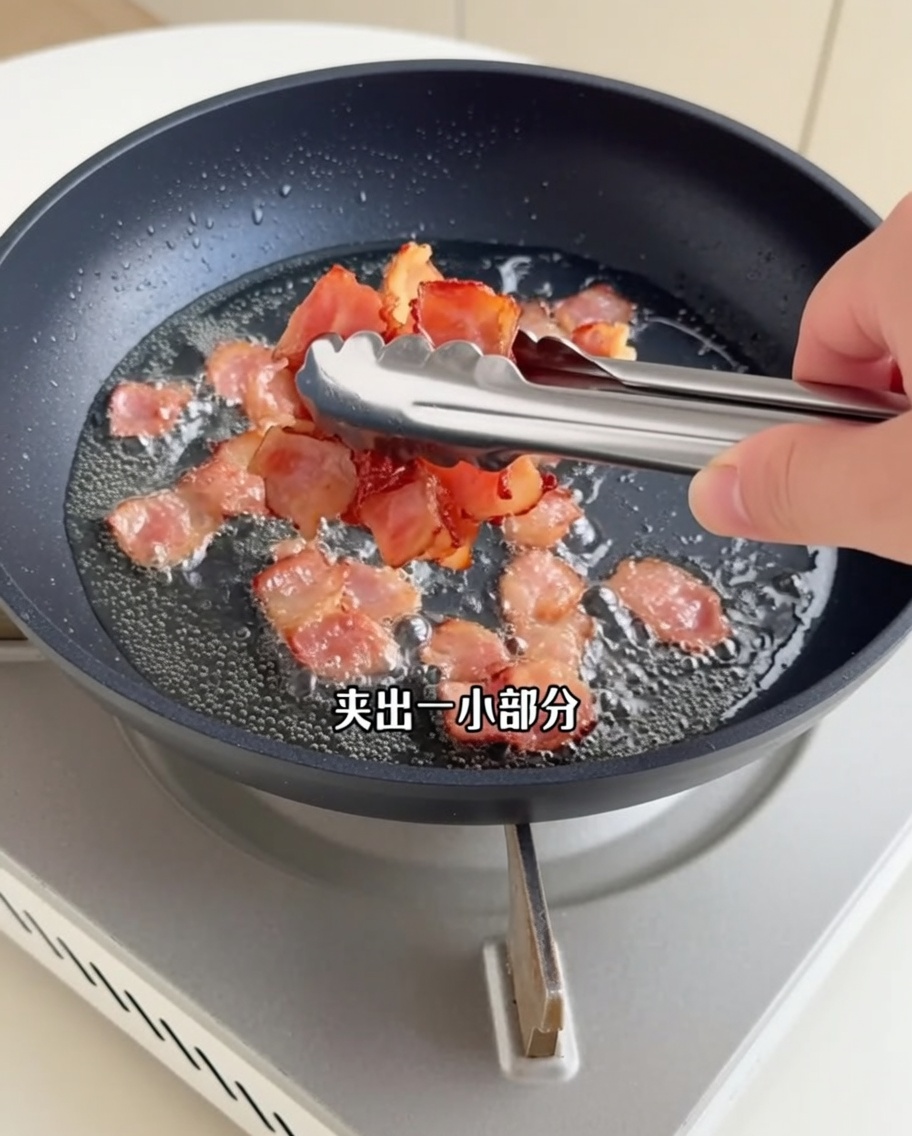 Crispy browned bacon pieces being lifted out of the pan with metal kitchen tongs.