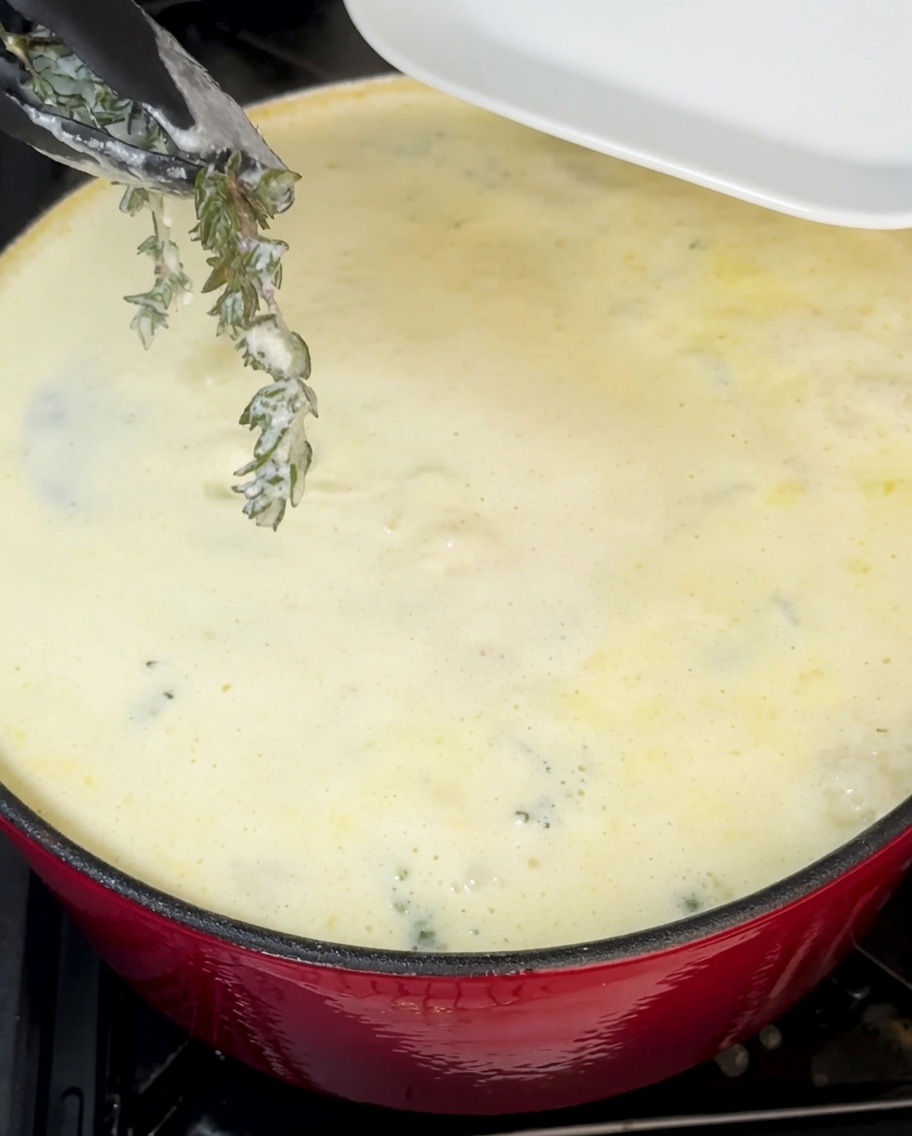 Freshly chopped green chives being stirred into the creamy clam chowder.