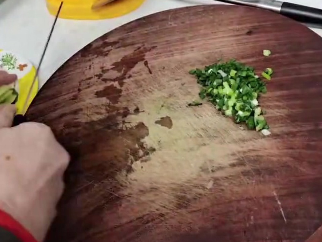 Bamboo shoot stems cut into small, uniform pieces on a wooden board.