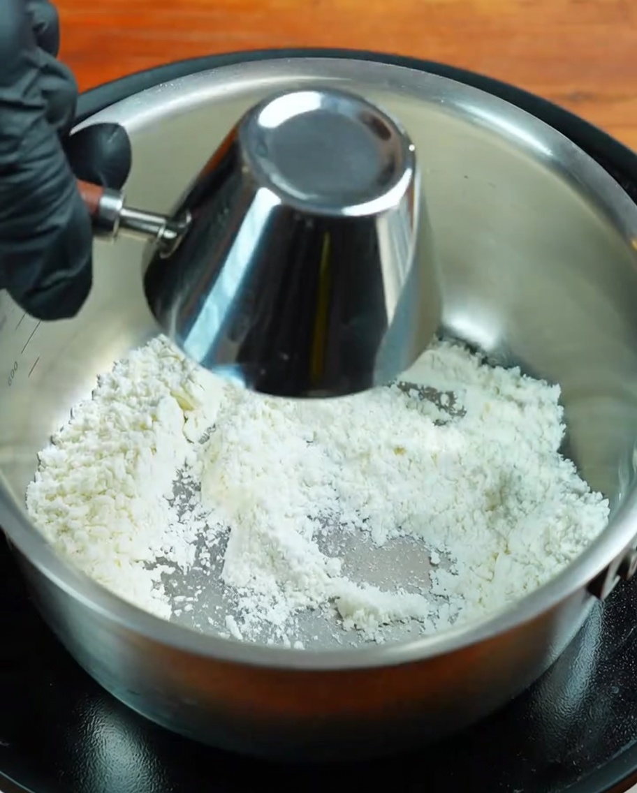 Whisking butter into the toasted flour until a smooth paste is formed.
