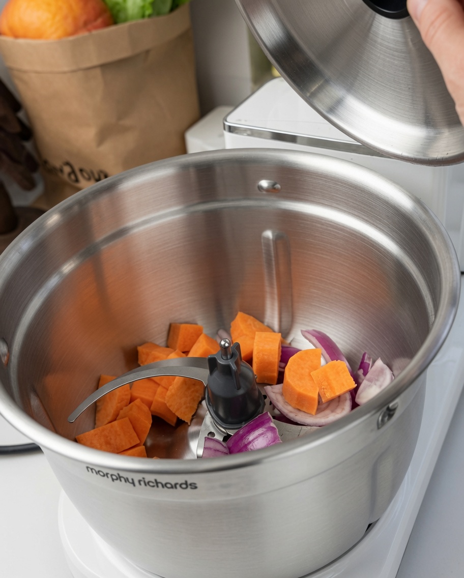 Carrots and red onions inside the mixing bowl with the blade.