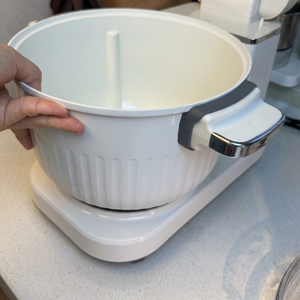 The ingredients for the pizza dough gathered inside the mixing bowl of the stand mixer.