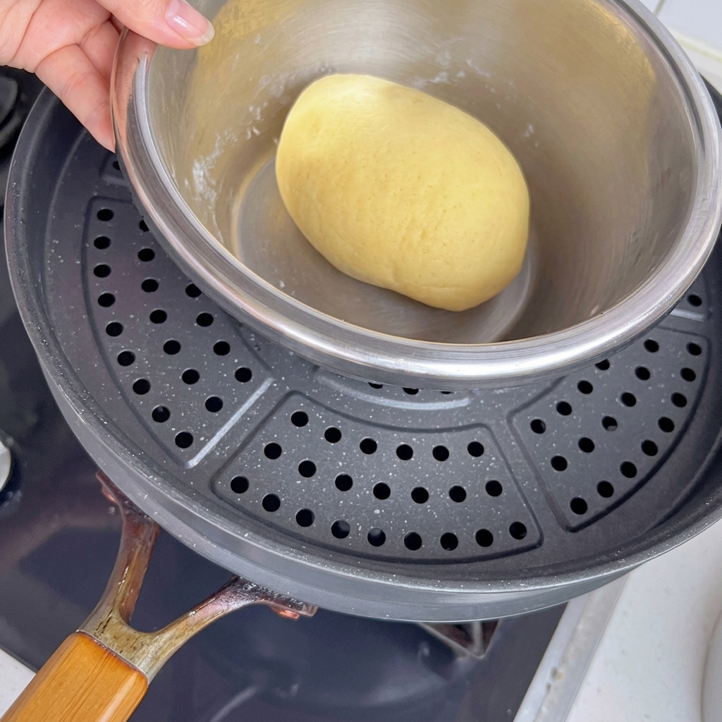 Dough bowl sitting inside a pot over warm water to facilitate proofing.