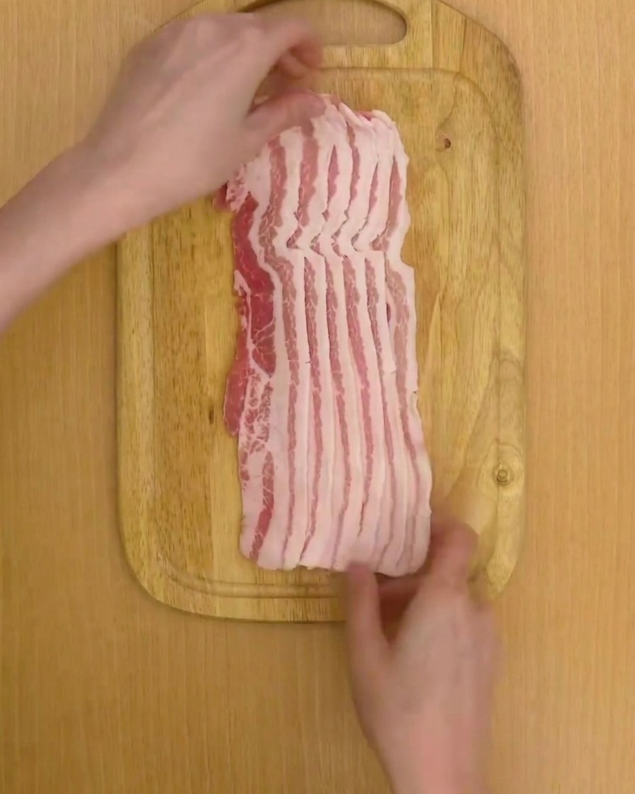 Two stacks of 6 pork belly slices neatly arranged on a wooden board.