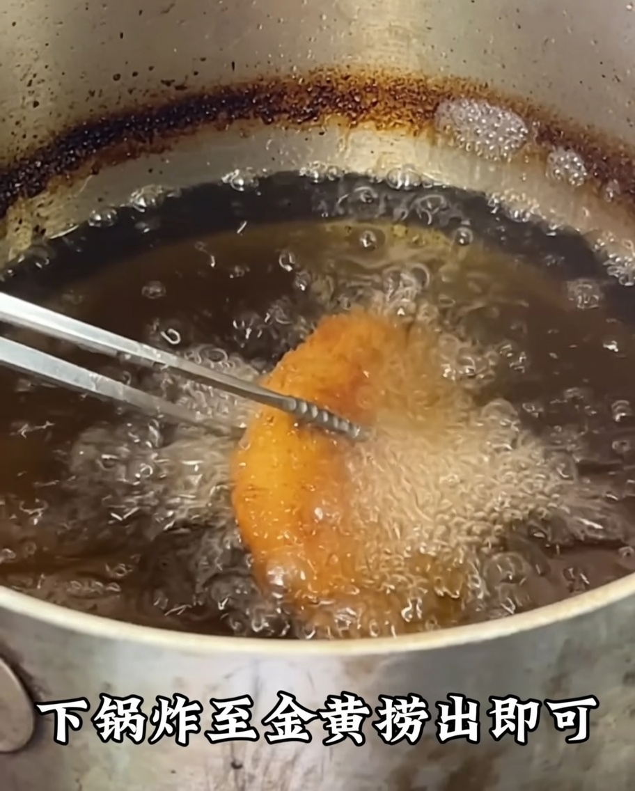 Breaded chicken cutlets frying in deep, hot oil until reaching a deep golden brown color.