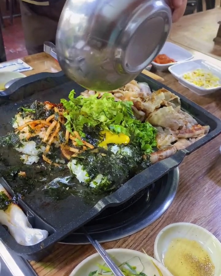 Kimchi and green onions added to the grill pan with the rice and pork.