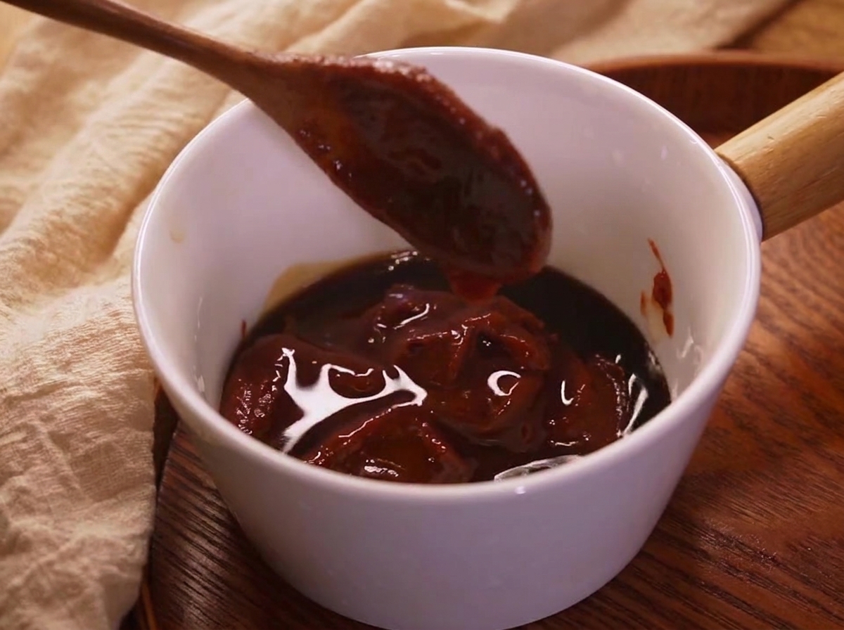 The prepared bibimbap sauce in a small bowl, showing a rich red color.