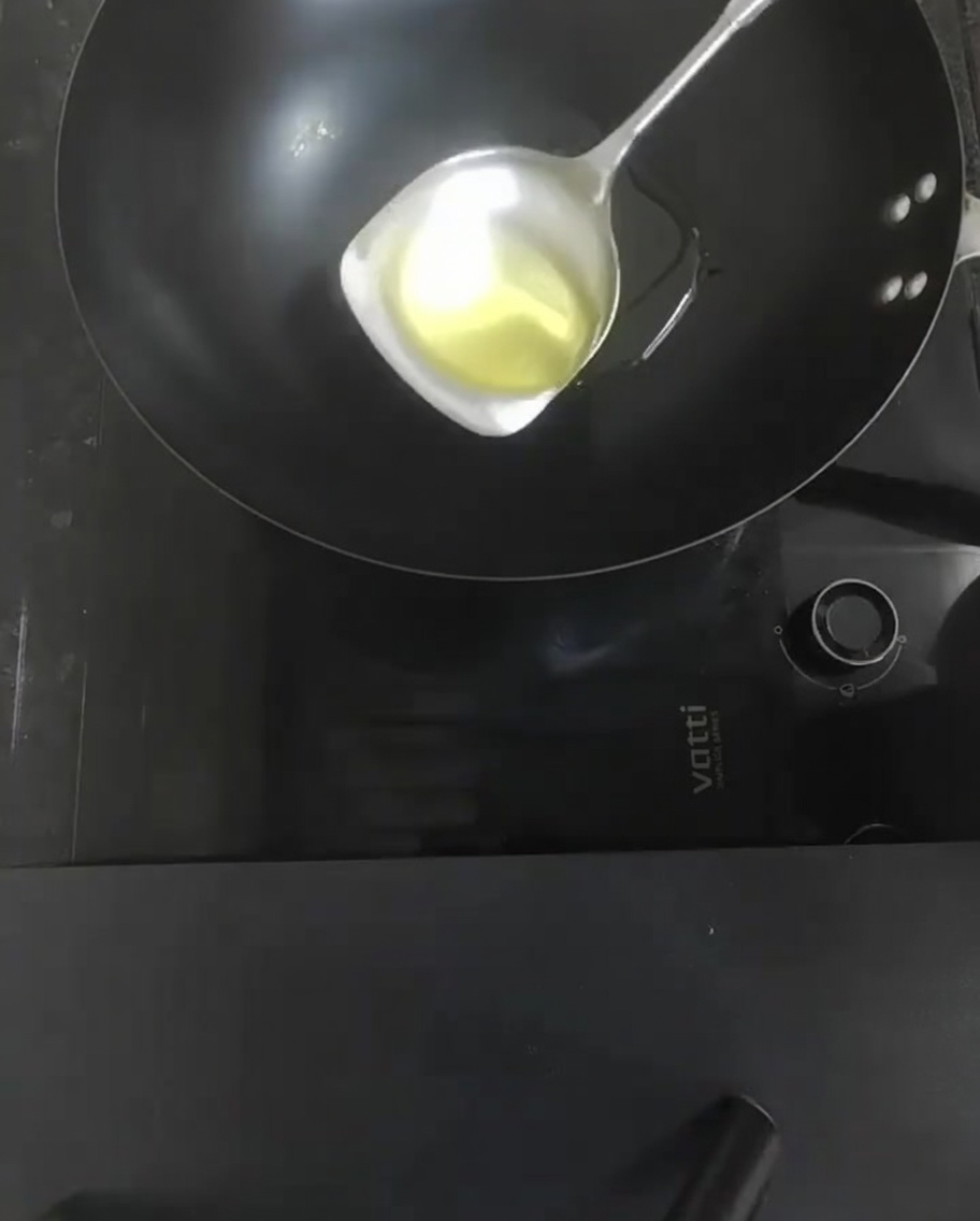 Peeled tomatoes being stir-fried in a hot wok, softening and releasing their juices.