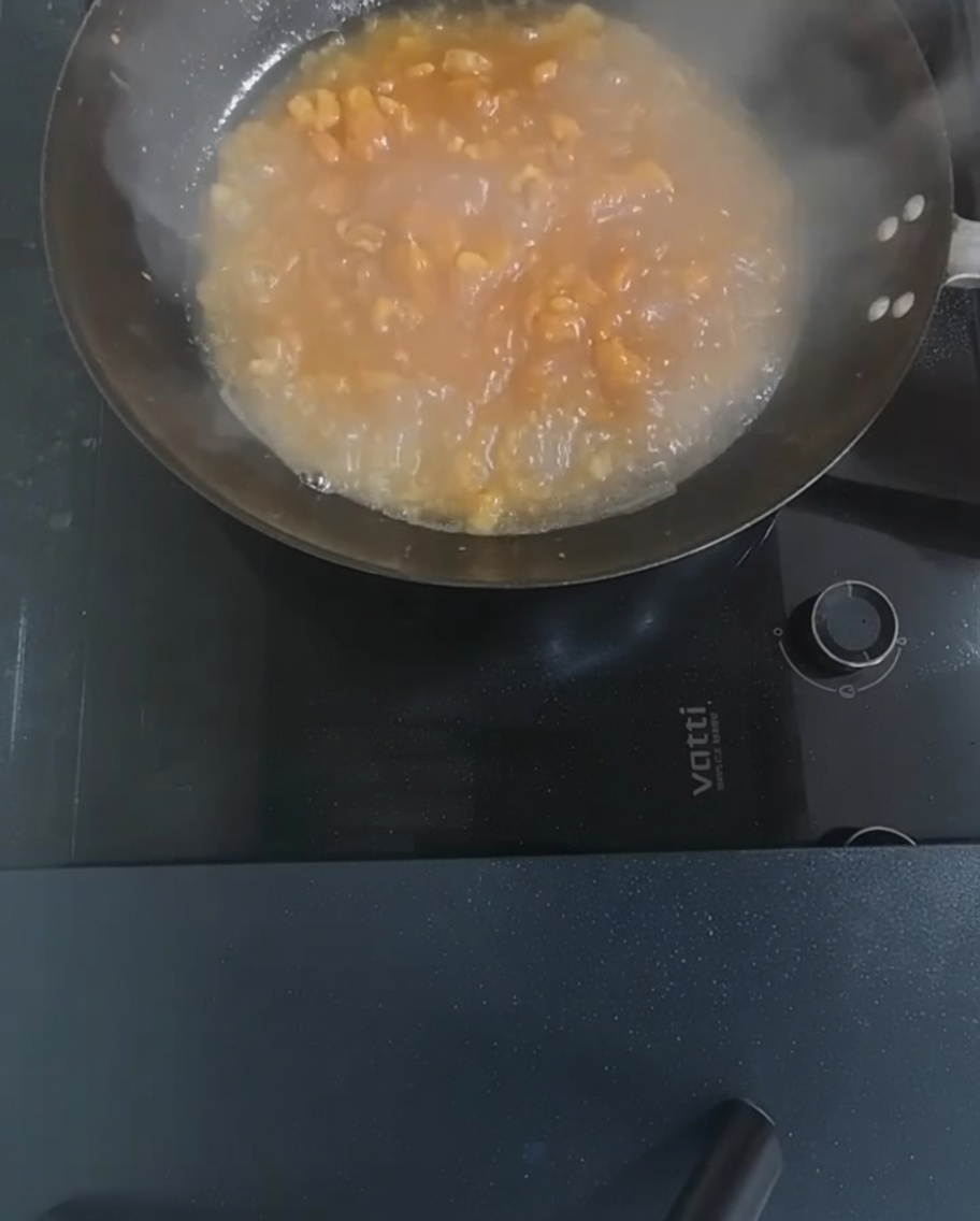 Tofu cubes and enoki mushrooms being added to the boiling soup in the wok.