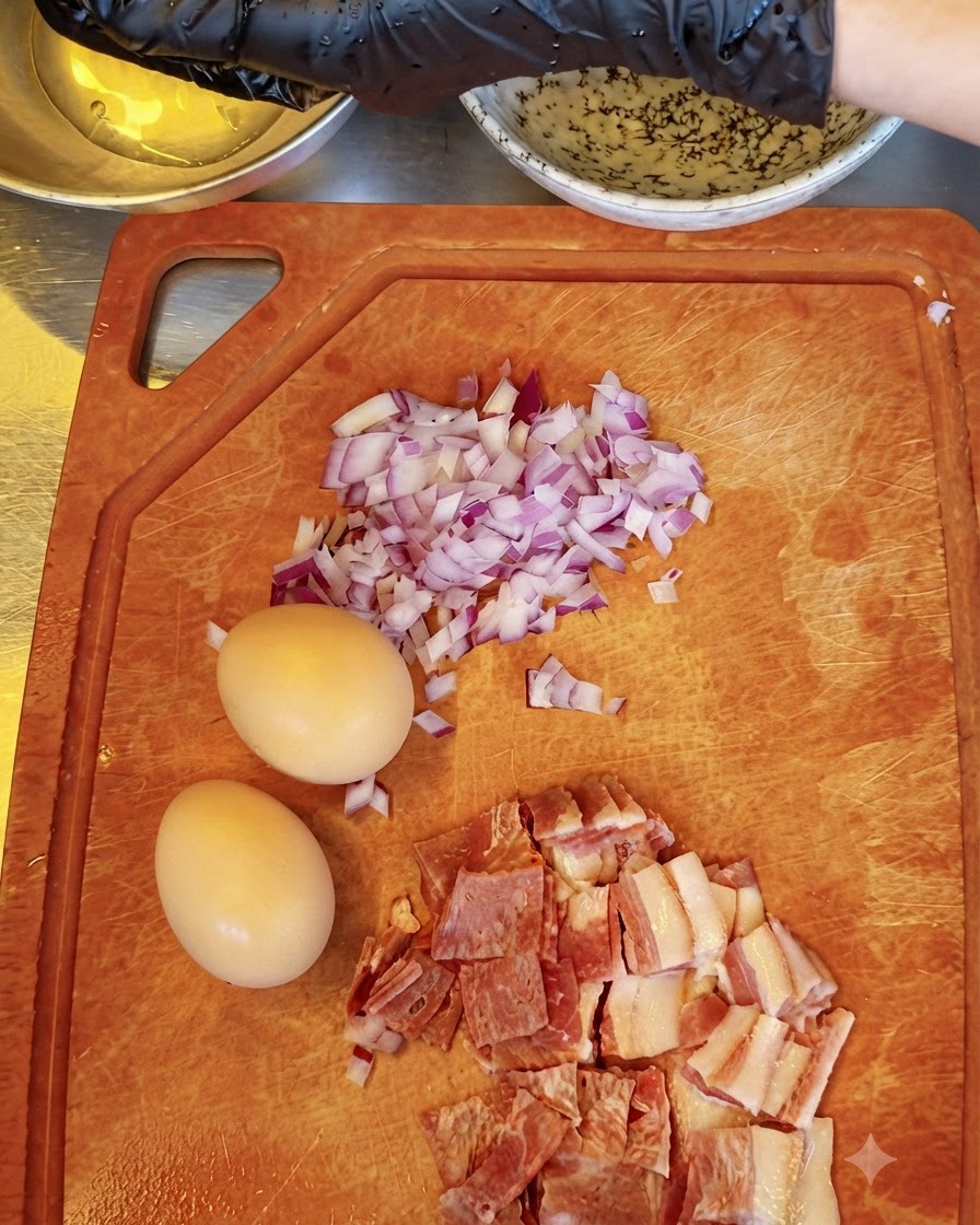 A person separating raw egg yolks with gloved hands, holding them above a bowl while other ingredients sit on a cutting board.