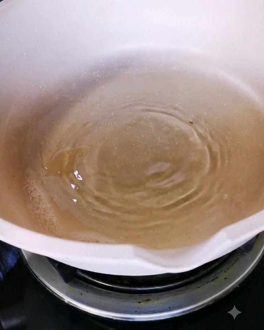 Olive oil being poured into a white ceramic pan on a stovetop burner.