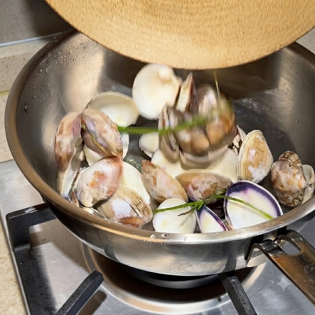 Empty clam shells and water boiling vigorously in a stainless steel pot.