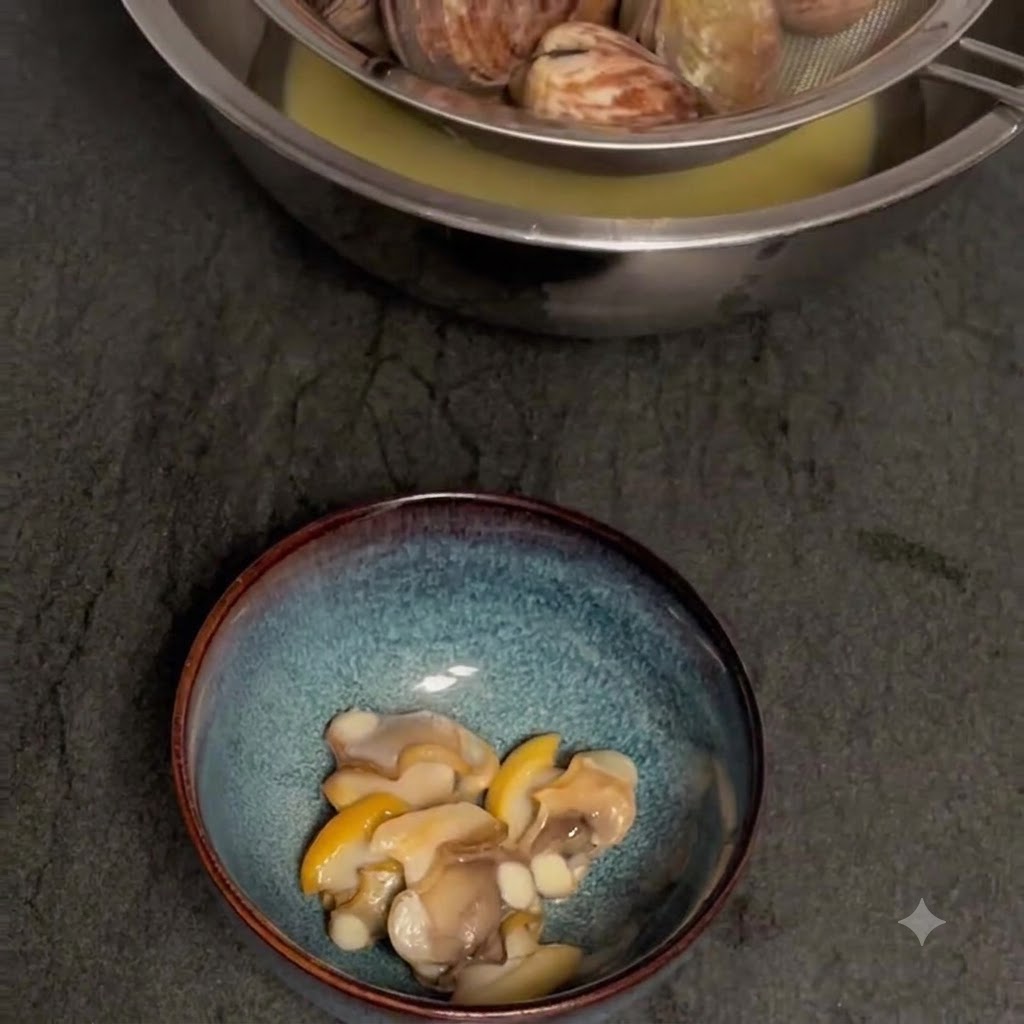 Straining cooked clams over a bowl to collect the broth, with shelled clam meat in a separate bowl below.