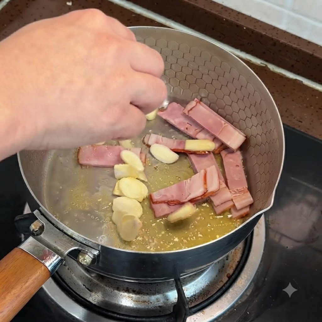 Sliced bacon and garlic pieces being stir-fried in a pan with melted butter.