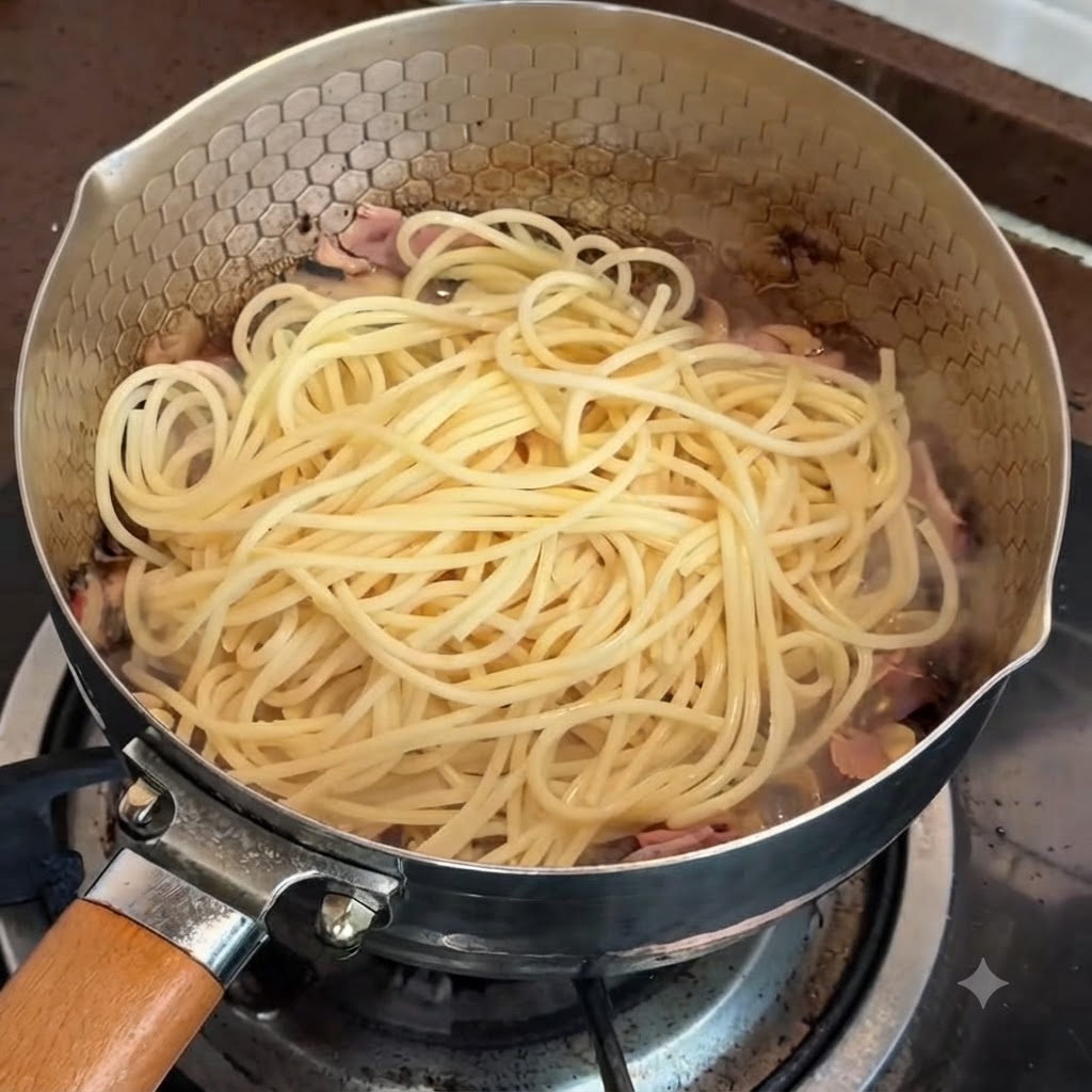 Pasta in a pan ready to be mixed with the truffle and egg yolk sauce.