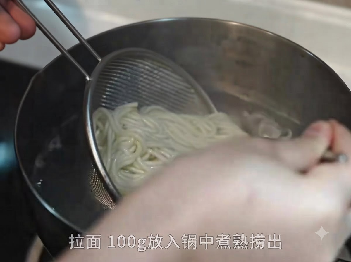 Scooping cooked ramen noodles out of a pot of boiling water with a metal mesh strainer and chopsticks.