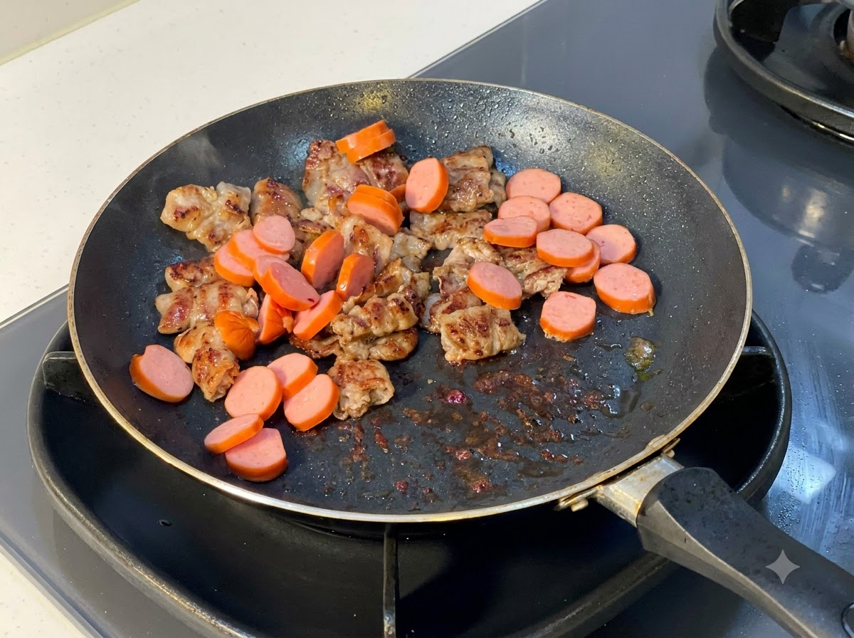 Sliced sausages being added into the pan containing cooked beef slices.
