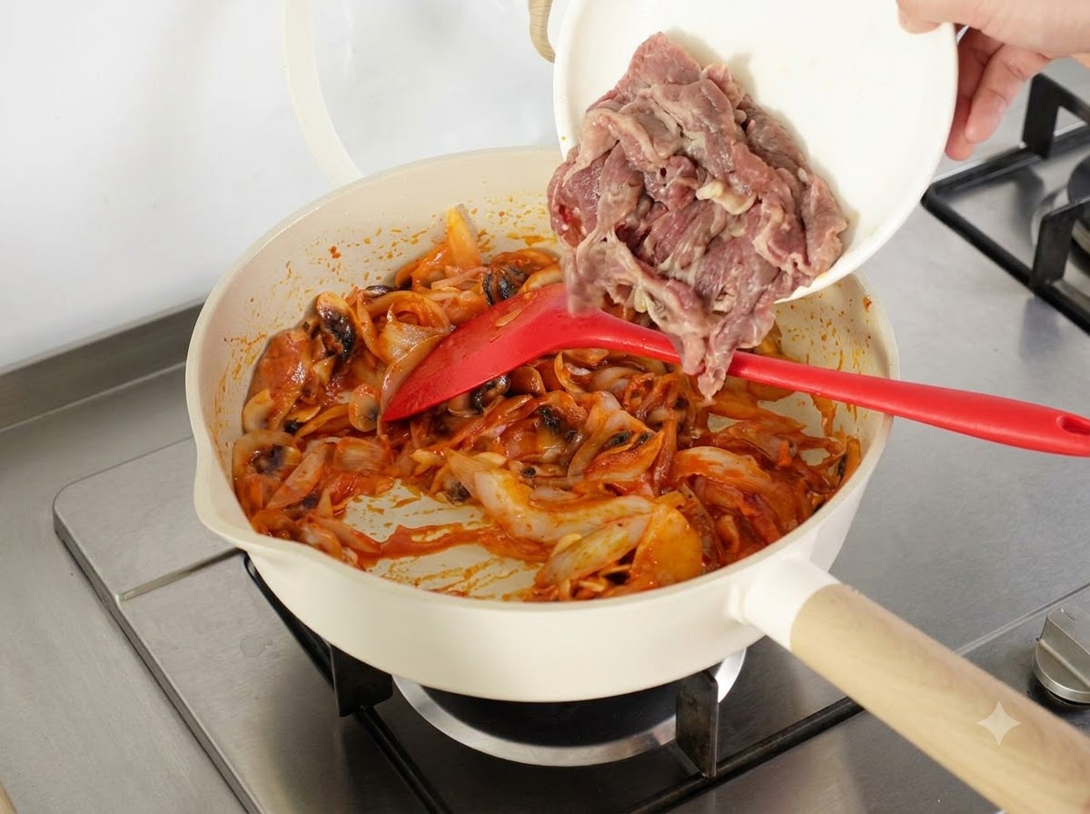 Parboiled beef slices and a bowl of overnight cooked rice being added into the pan.