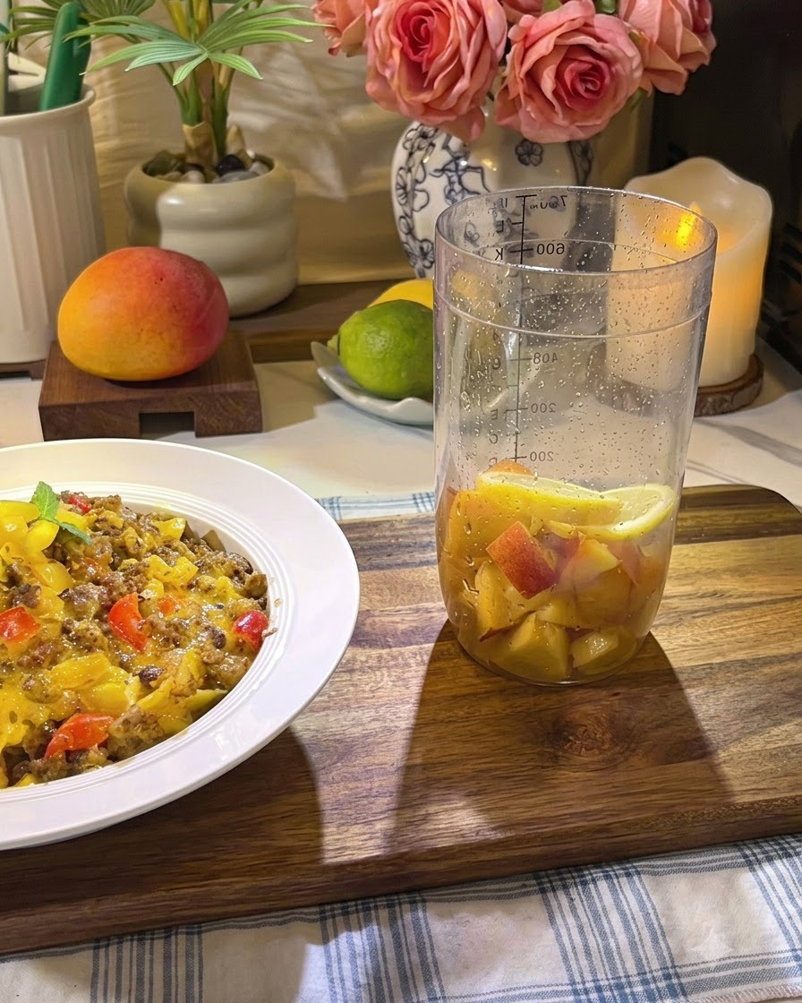 Fruit ingredients being firmly muddled inside a tall glass with a muddler.
