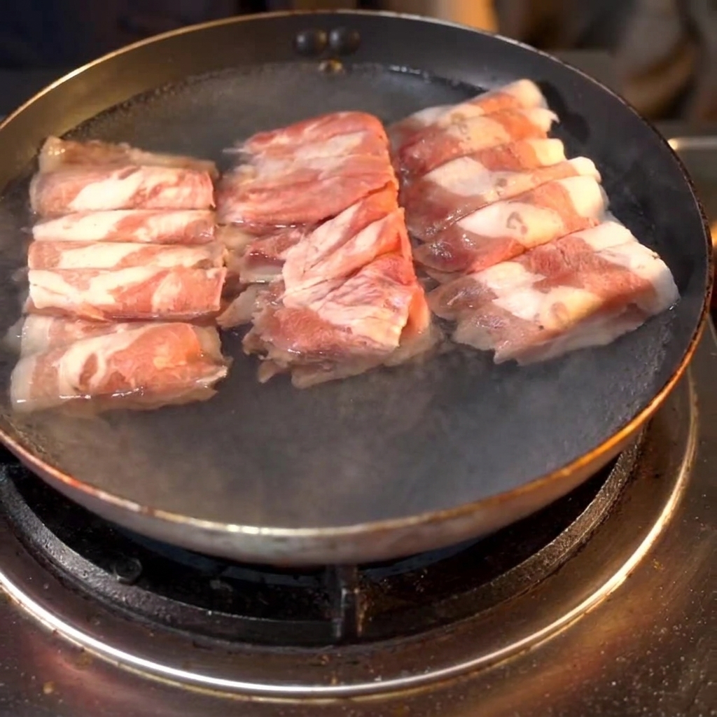 Beef rolls boiling in a pan with cooking wine added to the water.