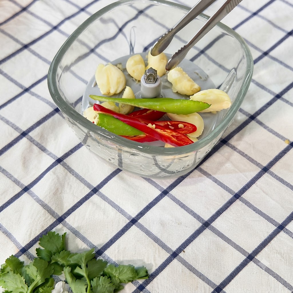 Chili peppers being chopped into a paste in the food chopper.