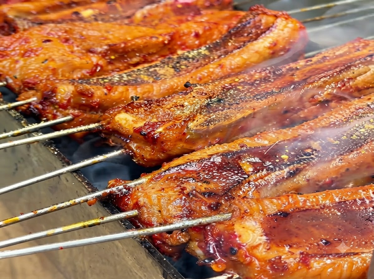 Yellow spice powder being sprinkled onto grilling ribs.