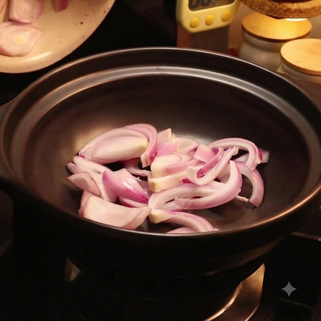 Fresh pieces of napa cabbage being arranged inside the black pot over red onion slices.