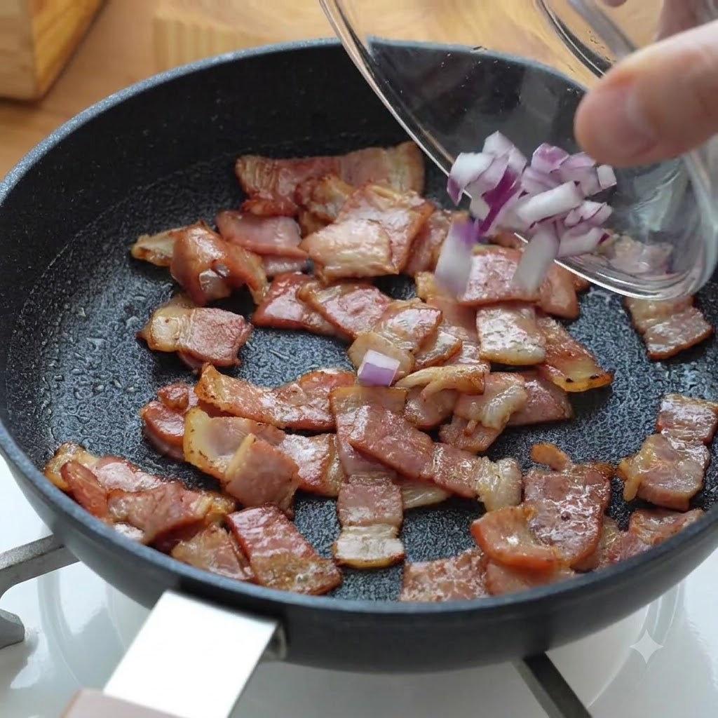 Chopped red onion pieces being poured into the pan with cooking bacon.