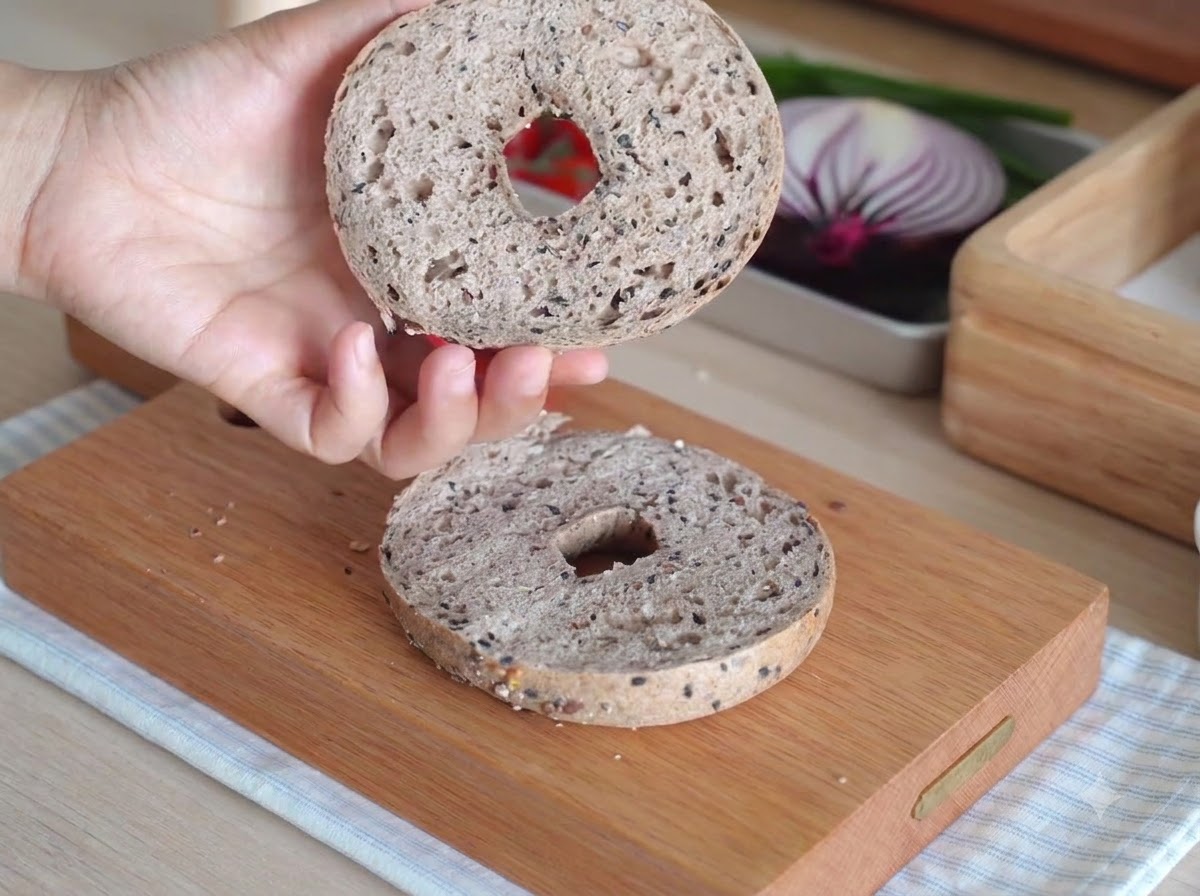 Two bagel halves inside a small white countertop oven during baking.