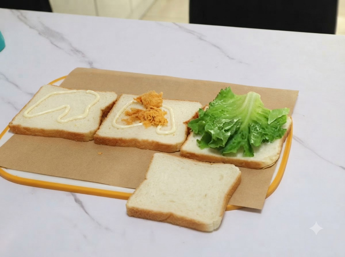 A clump of pork floss being transferred with tongs onto a slice of bread covered with dressing.