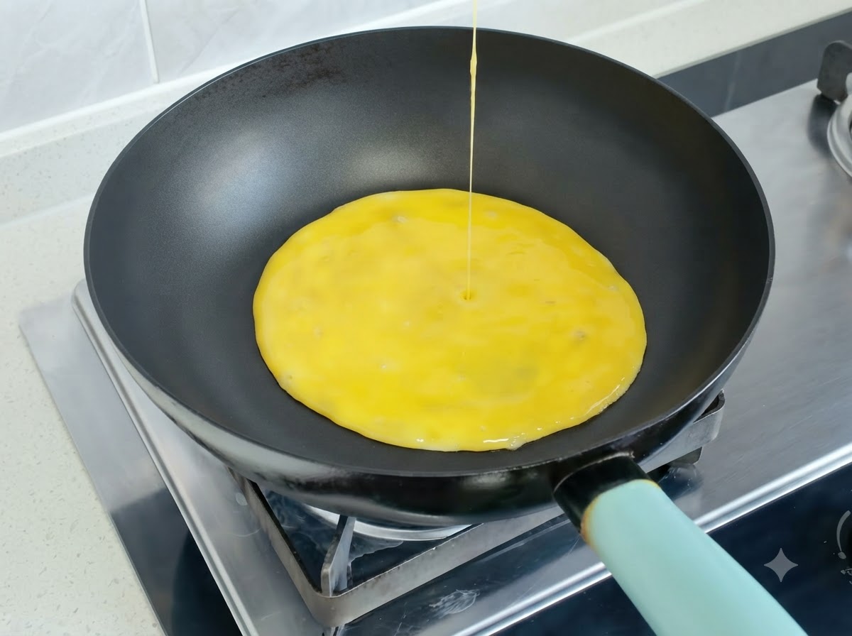 Beaten egg mixture being poured into a hot frying pan to form an omelette.