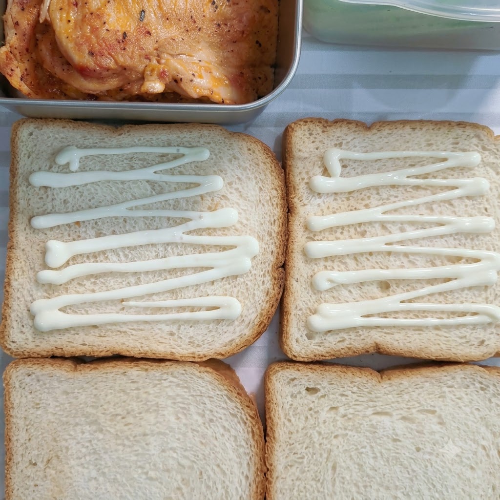 Sweet salad dressing drizzled in lines across four slices of white bread.