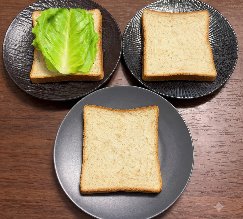 Fresh green lettuce leaves arranged neatly on top of whole wheat bread slices placed on black plates.