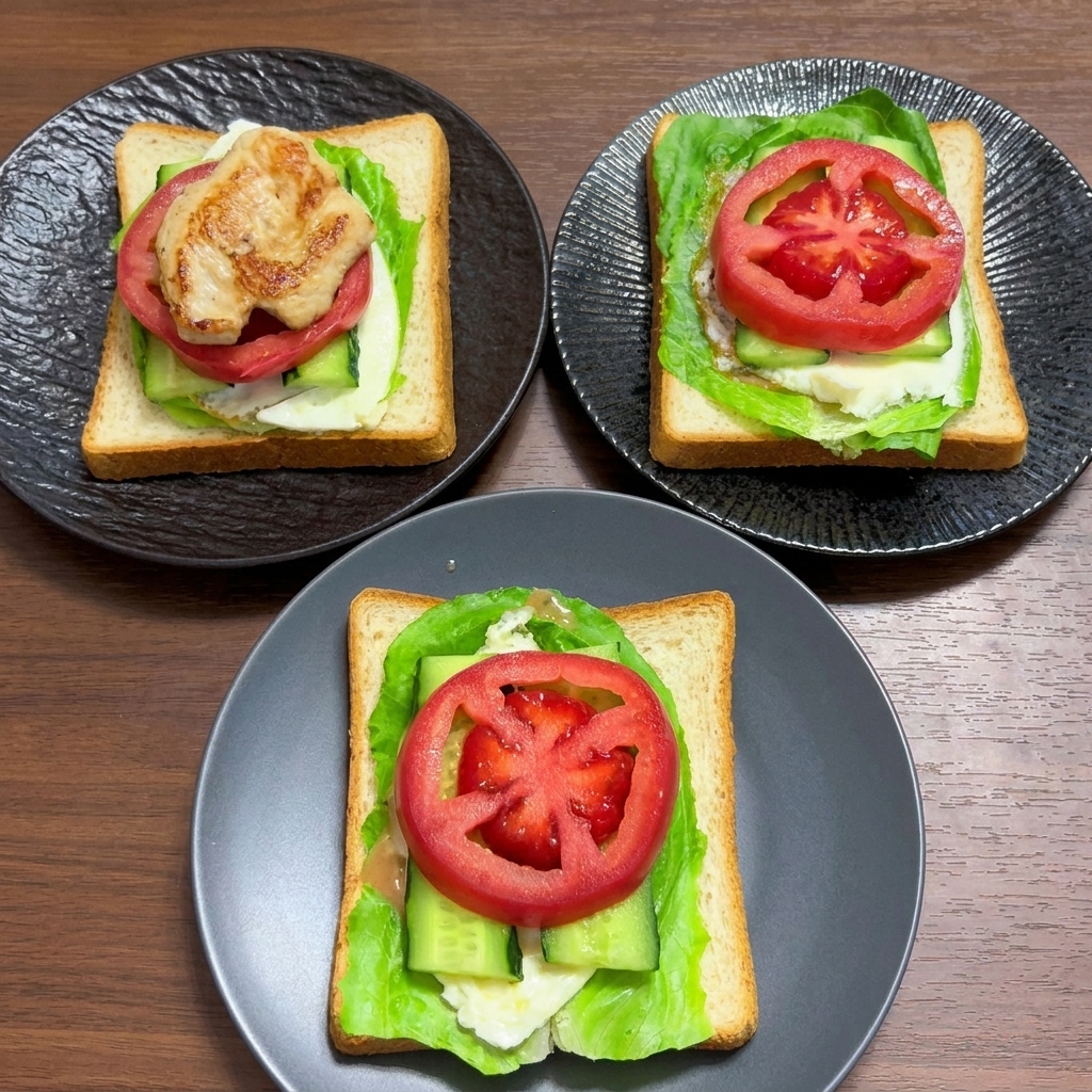 Whole wheat bread layers topped with lettuce, egg, cucumber, and thick slices of fresh tomato.