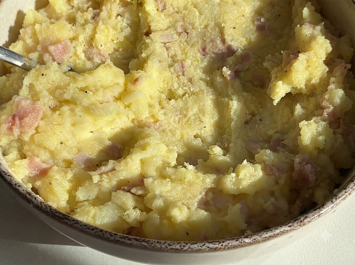 A bowl filled with the combined potato and ham mixture ready for stuffing.
