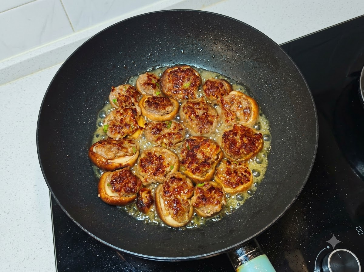 Water poured into the wok surrounding the pan-fried mushroom and meat pieces.