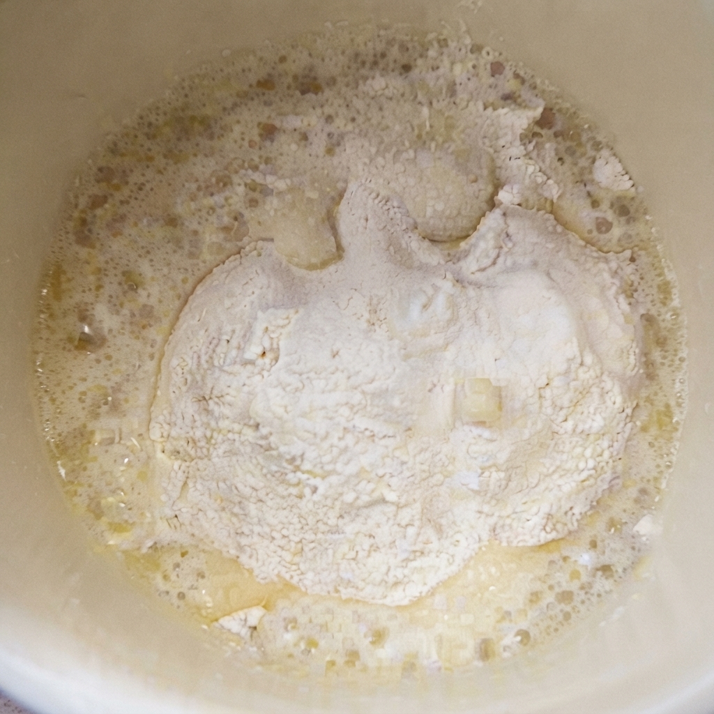 Hot oil being poured over flour and salt mixture to create an oil roux.