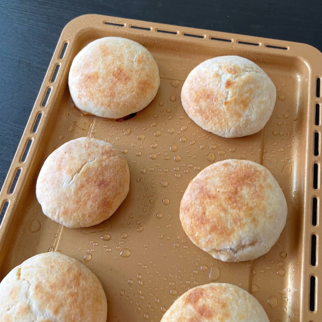 Rolled dough log being cut into equal portions using a bench scraper.
