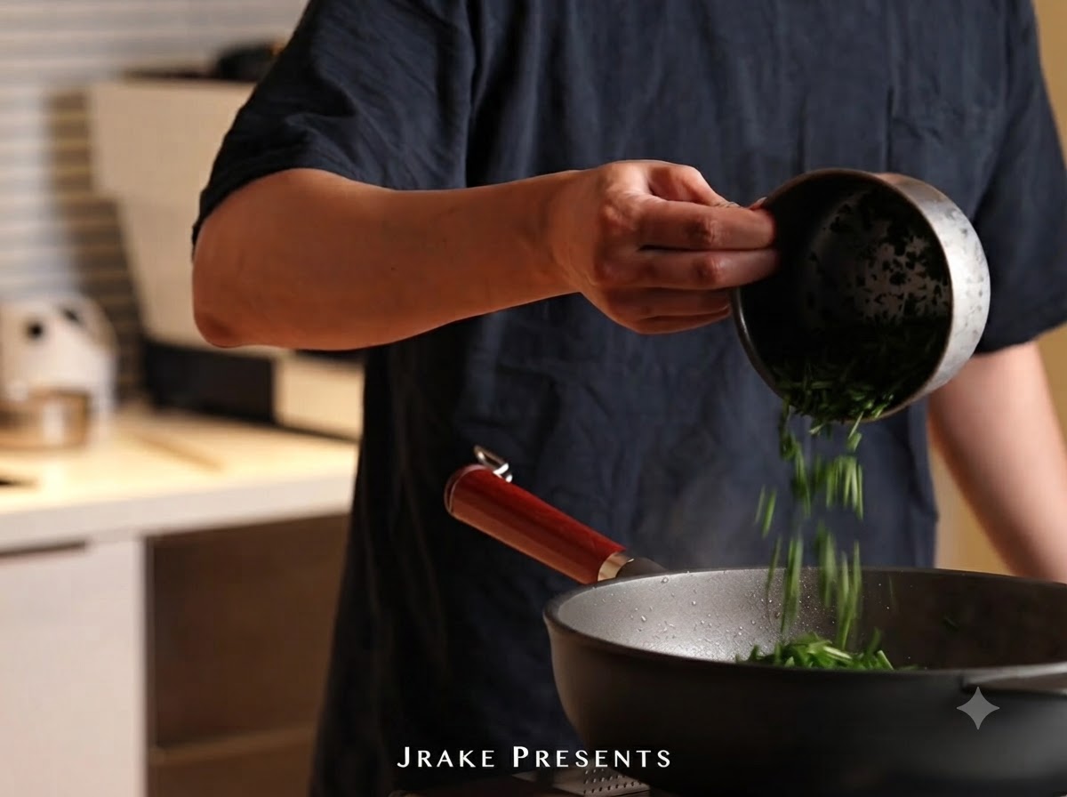 Chopped green parsley being poured from a small container into the pan of pasta.