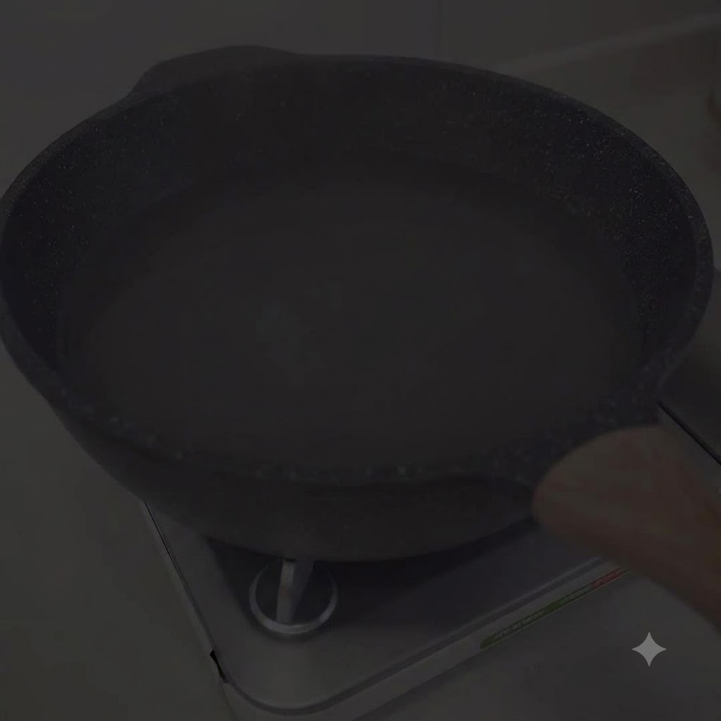 A pot of water heating on a stove burner.