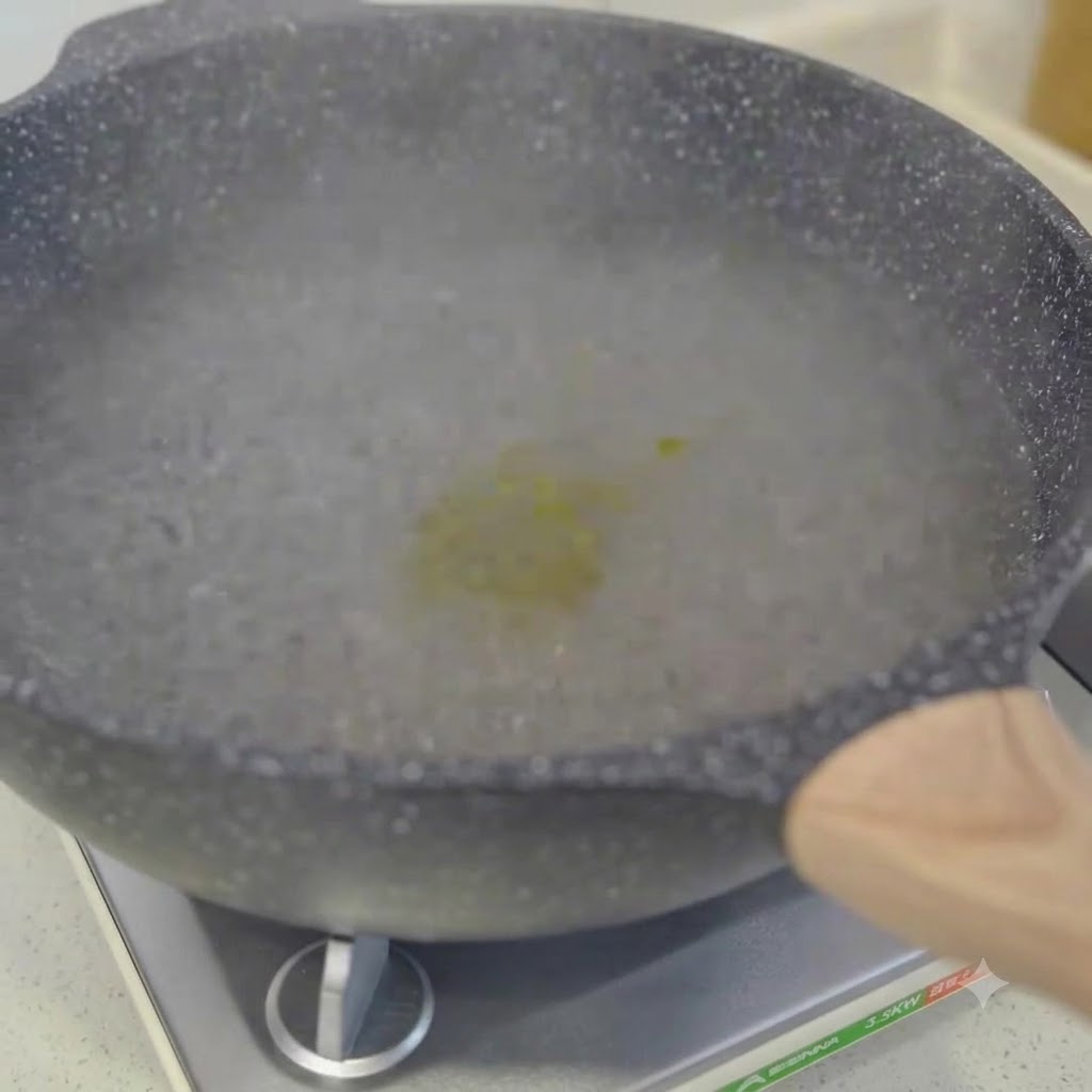 Spaghetti cooking in a pot of boiling water being stirred with chopsticks.