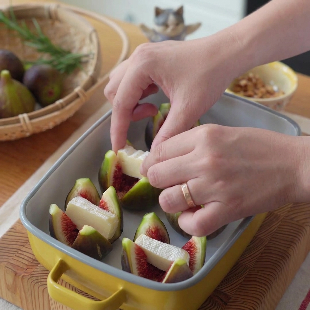 A hand placing a slice of white brie cheese into the opened center of a cross-cut fig.